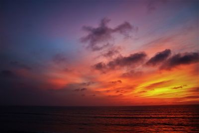 Scenic view of sea against dramatic sky during sunset