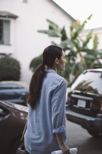 Rear view of design professional with paper walking against car