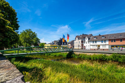 View of arch bridge in city against blue sky