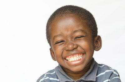 Portrait of smiling boy against white background