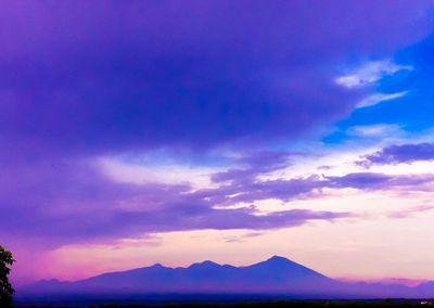 Scenic view of silhouette mountains against blue sky