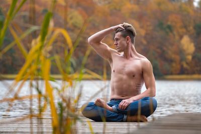 Young man sitting in lake