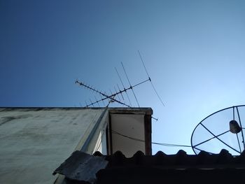 Low angle view of windmill against clear blue sky