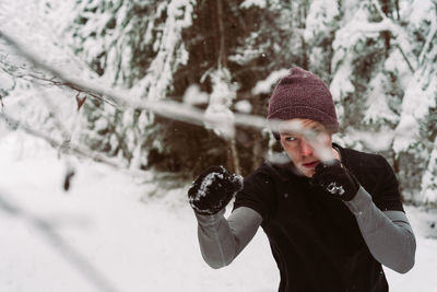 Man jumping by snowy tree