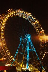 Low angle view of illuminated ferris wheel against sky at night