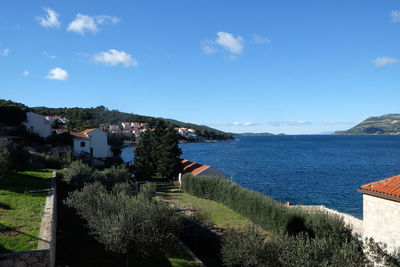 High angle view of townscape by sea against sky