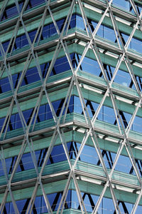 Low angle view of glass building against blue sky