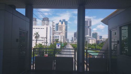 Modern cityscape against sky seen through window