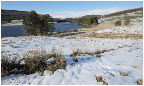 Scenic view of snow covered land against sky