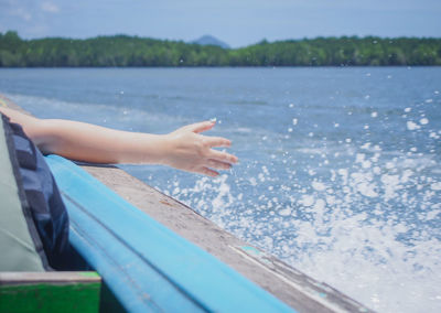 Cropped image of woman sitting on boat in sea
