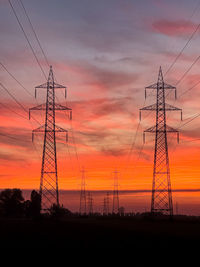 Silhouette electricity pylon against sky during sunset
