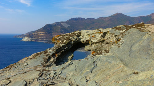 Scenic view of sea and mountains against sky