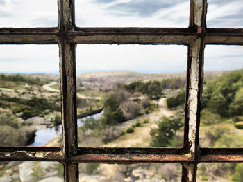 Close-up of window on landscape against sky