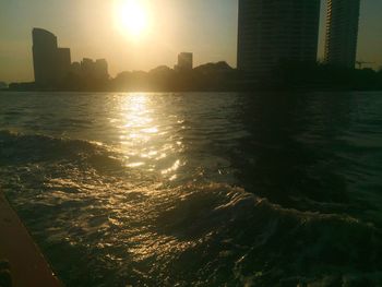 View of city at waterfront during sunset