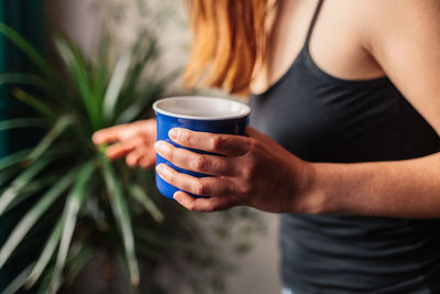 Midsection of woman drinking coffee