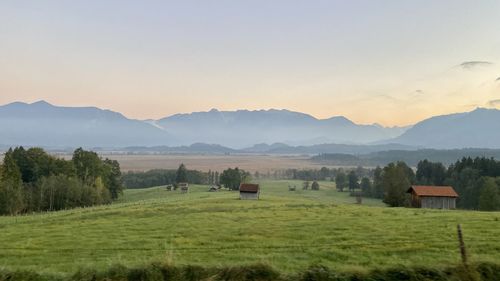 Scenic view of field and mountains against sky