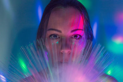 Close-up portrait of young man with illuminated fiber optics