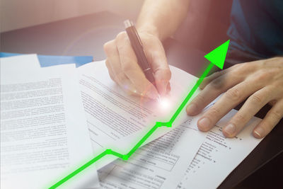 Midsection of woman reading book on table