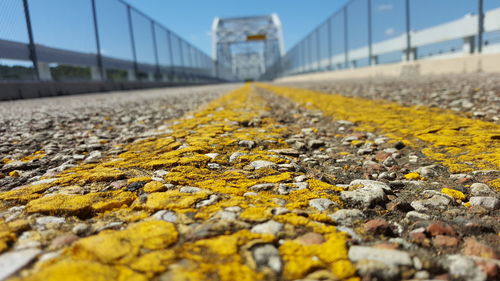 Surface level of yellow road against bridge