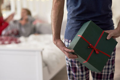 Man holding gift with family at home