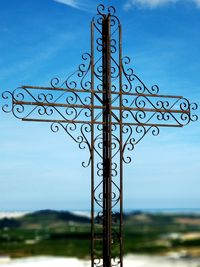 Close-up of cross against blue sky