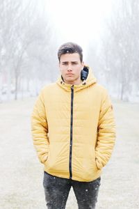 Portrait of man standing on snow covered field