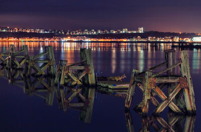 Boats moored in water at night