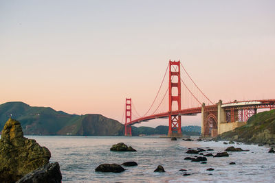 Suspension bridge over sea against sky