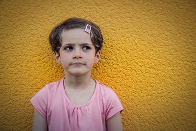 Innocent girl against yellow wall