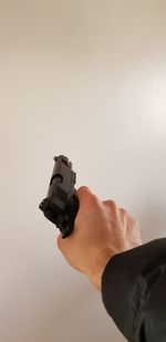 Cropped hand of man holding gun