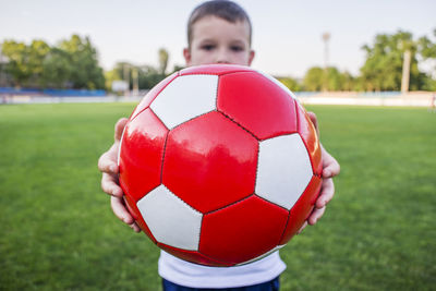 Low section of man playing soccer at park