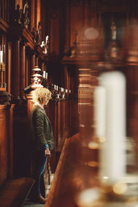 Side view of young woman standing in church