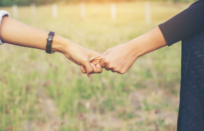 Midsection of couple holding hands