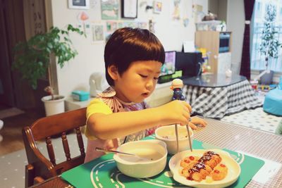 Boy having food at table