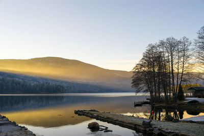 Scenic view of lake against sky at sunset