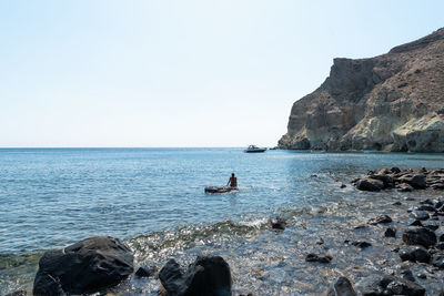 Scenic view of rocks in sea against clear sky