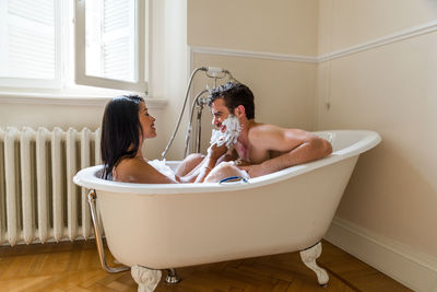 Side view of woman sitting in bathroom