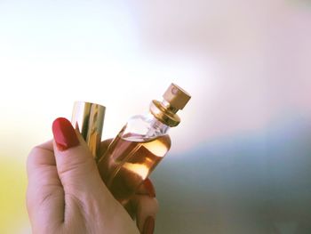 Cropped hand of woman holding perfume