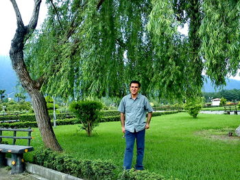 Portrait of young man standing against trees