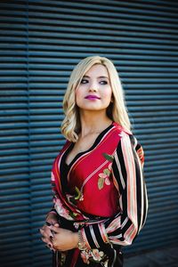 Portrait of a beautiful young woman standing against wall