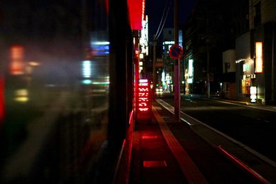 Road passing through illuminated city at night