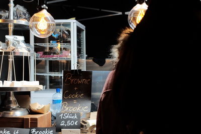 Midsection of woman at illuminated store