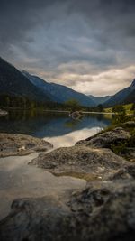 Scenic view of lake by mountains against sky