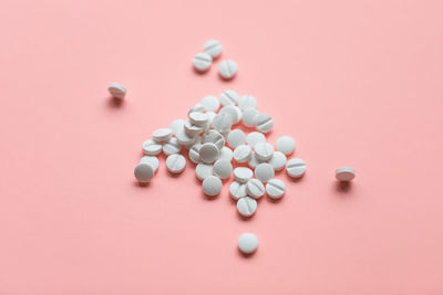 Pills on pink background, supplement and medicine concept. closeup, copy space