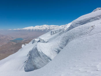 Scenic view of snowcapped mountains against blue sky