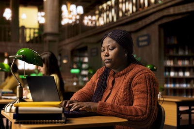 Portrait of young woman using laptop at home