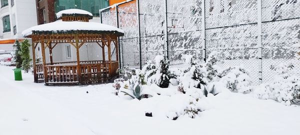 Snow covered field by building