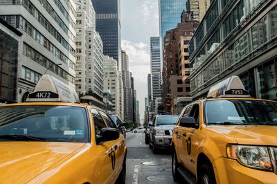 Vehicles on road amidst buildings in city