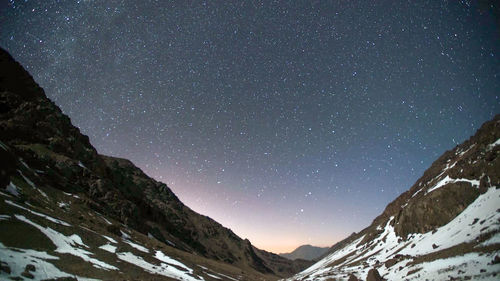 Scenic view of snowcapped mountains against sky at night