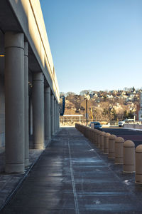 Walkway in city against clear sky